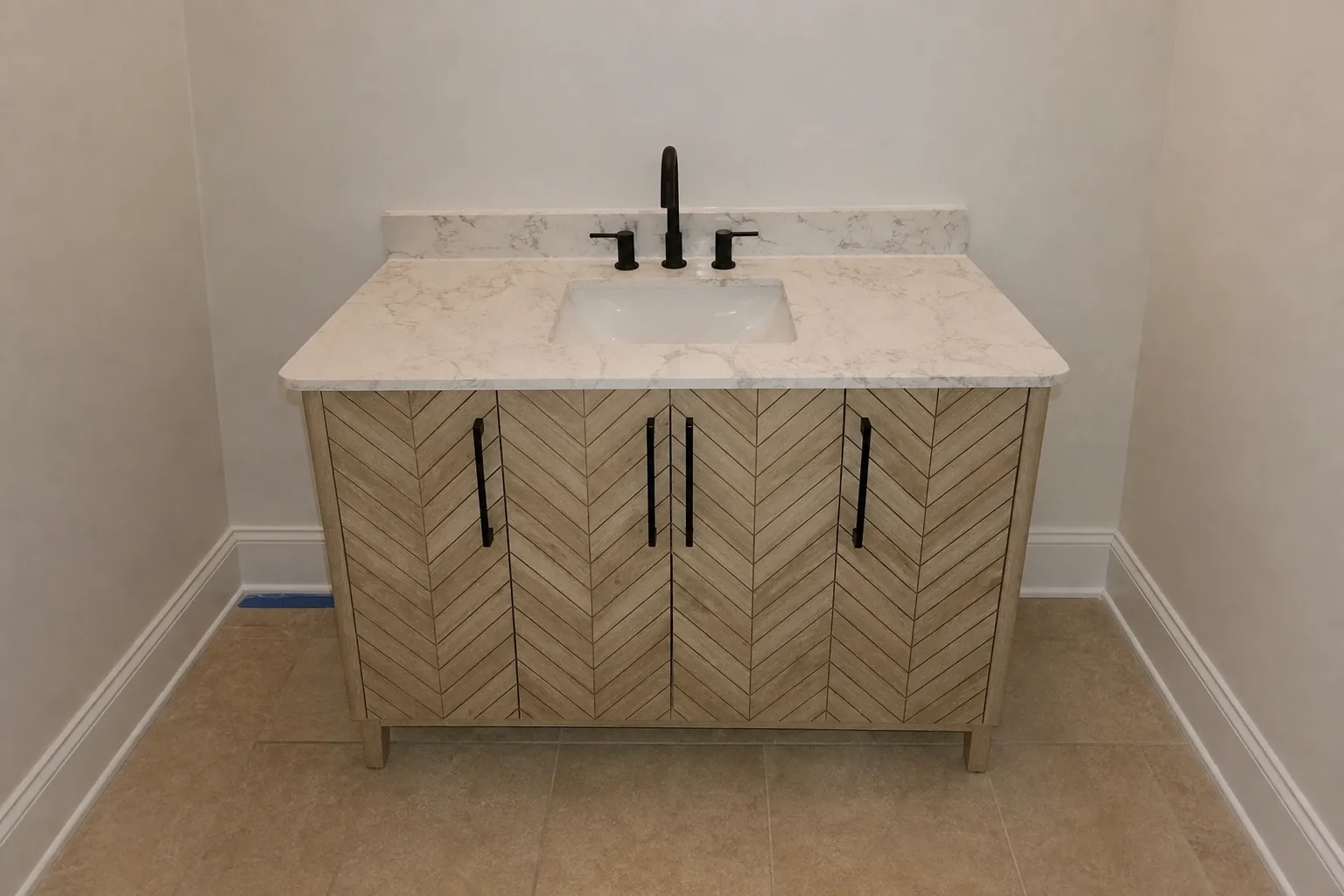 Chevron-front vanity with quartz top installed in a Charlotte bathroom